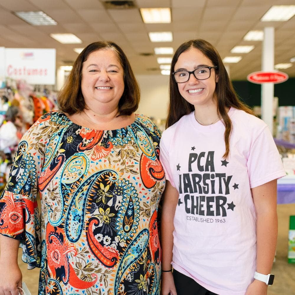 Mom holds daughter who is sleeping in her arms while she shops the local JBF sale.